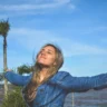 A happy woman with outstretched arms.