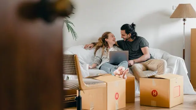 Happy couple sitting on the couch in their new home.