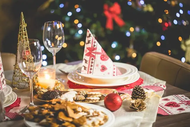 Set a table in front of a Christmas tree.