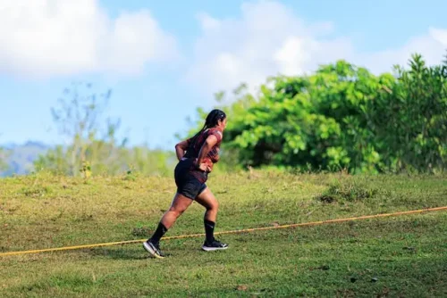 Woman running uphill to increase intensity and burn more calories during a workout.