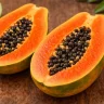 Ripe papaya cut in half showing bright orange flesh and black seeds illustrating what does papaya taste like and the fruit's soft juicy texture