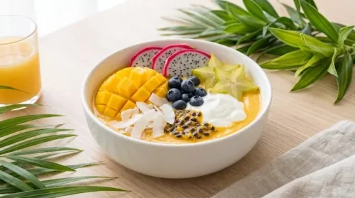 Passion fruit smoothie topped with tropical fruit and seeds